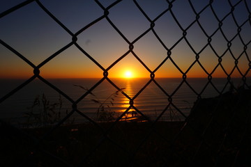 Sunset through a fence