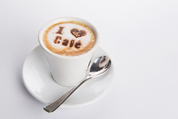coffee with milk with a delicious foam with the inscription in cocoa of I love coffee on white background
