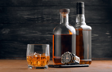 Still life. pour or whiskey in to glass. Wooden table