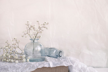 small vases with airy flowers on a shelf at home