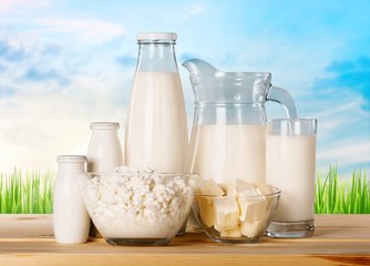 Glass of milk and dairy products on background