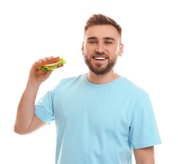 Young man with tasty sandwich on white background