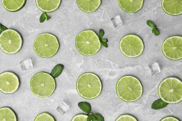 Flat lay composition with slices of fresh juicy limes on marble table