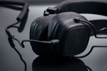 Fototapeta na wymiar black headphones on a glossy table close-up