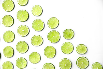 Slices of fresh juicy limes on white background, flat lay