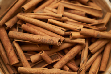 Cinnamon sticks in ceramic bowl, close-up, food background