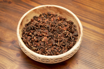 Anise stars in ceramic bowl, close-up. Dry anise stars