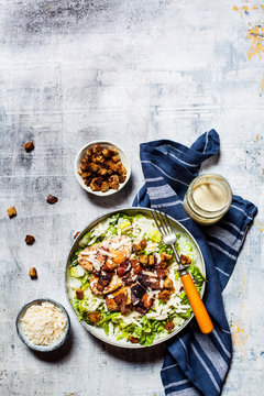 Bowl of Caesar salad with romaine lettuce, Parmesan cheese, bacon, chicken breast and croutons
