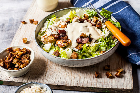 Bowl of Caesar salad with romaine lettuce, Parmesan?cheese, bacon, chicken breast and croutons