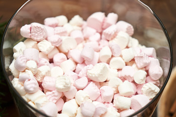 Fototapeta na wymiar Pink marshmallows in silver bowl, close-up. Sweet marshmallows
