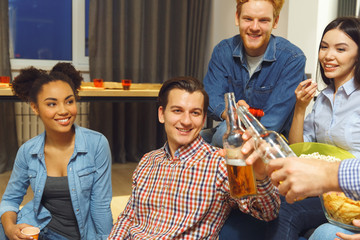 Group of friends having party indoors fun together guys cheers close-up