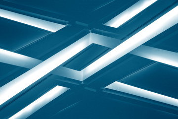 Lamps on dropped ceilings. Abstract modern architecture of an office building interior resembling glowing girders. Technological or geometric background with parallel lines.