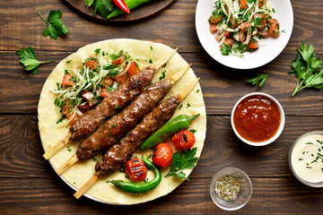 Turkish Adana Kebab with fresh vegetables on flatbread