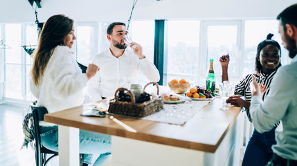 Couple talking to friends at Christmas party