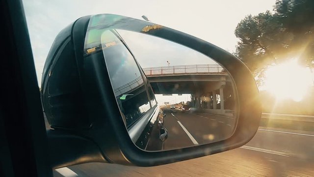 Close up footage of a car rear view mirror, at dusk.