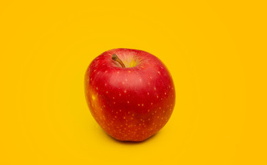 Close up photo of Fresh red apple on yellow background