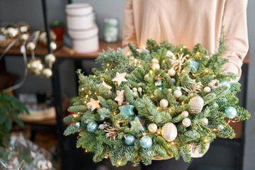 Obraz na płótnie Canvas Big arrangement of fresh spruce in a wicker basket. Christmas mood. Beautiful bouquet in womans hands..