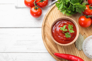 Flat lay composition with tomato sauce on white wooden table, space for text