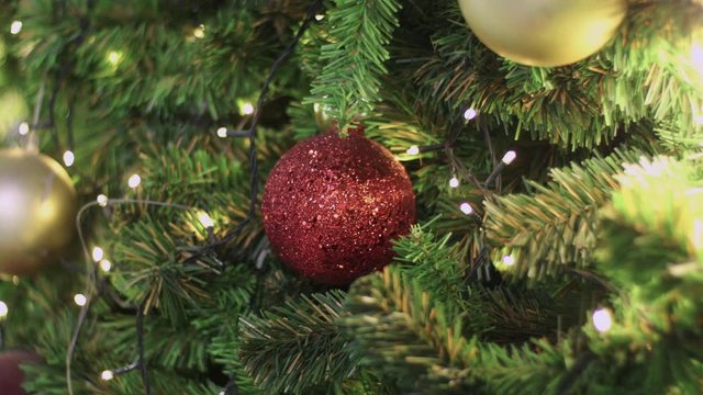 4k Close up, gold red decoration ball hanging on Christmas tree, X'mas and happy new year display, amber warm light, movement shot, holidays decoration events, joyful, fun time, happiness, bressed