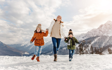 happy family mother and children having fun on winter walk.
