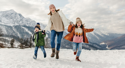happy family mother and children having fun on winter walk.