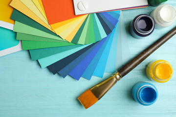 Flat lay composition with color palettes on light blue wooden background