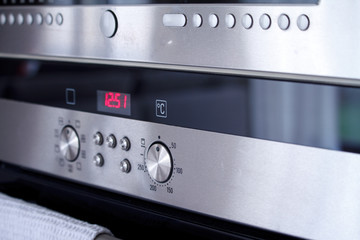Close-up the front panel of the oven with control poles and switching baking modes, selective focus
