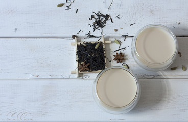 Traditional indian drink - masala tea with spices on white wood background
