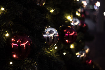 Christmas decorations on beautiful green Christmas tree with garland.