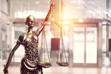 Statue of the lady of justice with scales on the background