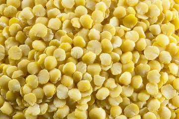 Uncooked raw yellow lentil texture background, heap of legume lentil concept (Lens culinaris)