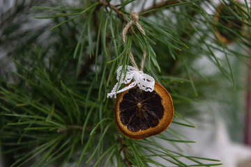 Closeup of dried citrus slices on the Christmas tree on wooden rustic background. Alternative eco friendly Christmas tree decoration concept