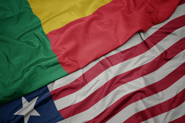waving colorful flag of liberia and national flag of benin.