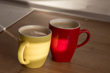 Two cups of cappuccino with latte art on wooden background. Beautiful foam, greenery ceramic cups, stylish toning, place for text.
