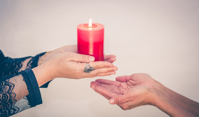 A picture of a woman holding a candle to perform magic rituals and mysteries about superstition in...