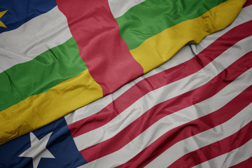 waving colorful flag of liberia and national flag of central african republic.