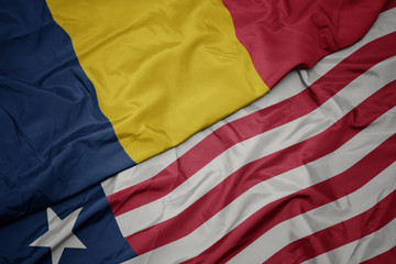 Obraz premium waving colorful flag of liberia and national flag of chad.