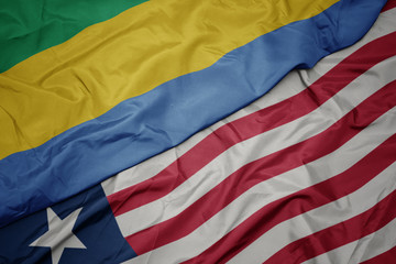 waving colorful flag of liberia and national flag of gabon.