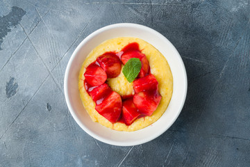 Millet porridge with peach on grey table