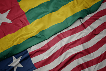 waving colorful flag of liberia and national flag of togo.