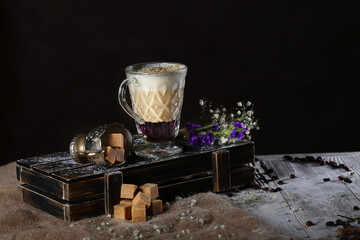 Non-alcoholic coffee drink with lavender syrup. Photo on black background. The drink is served in layers. Copy space.