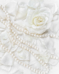 Beautiful white rose and pearl necklace on a background of petals. Ideal for greeting cards for wedding, birthday, Valentine's Day, Mother's Day