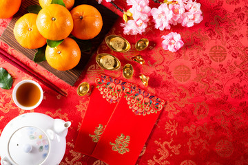 Chinese new year festival decorations pow or red packet, orange and gold ingots or golden lump on a...