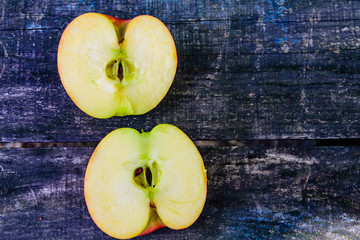 Halved ripe apple on a wooden table. Top view