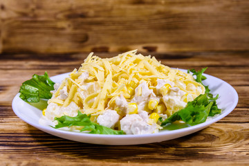 Festive salad with chicken breast, canned pineapple, cheese, sweet corn and mayonnaise on wooden table