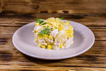 Festive salad with chicken breast, canned pineapple, cheese, sweet corn and mayonnaise on wooden table