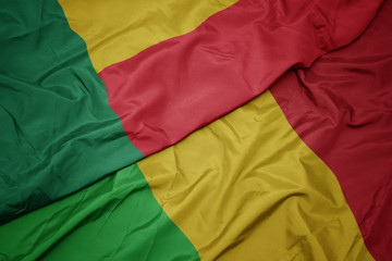 waving colorful flag of mali and national flag of benin.