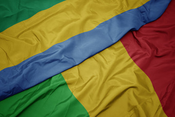 waving colorful flag of mali and national flag of gabon.