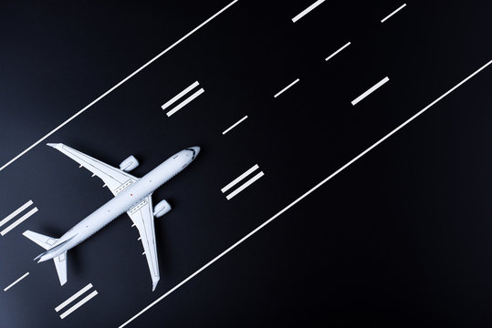 Airplane on black runway. Top view on aircraft. Concept of business travel and aerospace indusrty