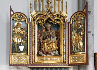 Fototapeta na wymiar San Valentino tra i Santi Isidoro e Urbano; altare scolpito nella chiesa parrocchiale di Santa Maria Assunta a Velturno (Alto Adige)